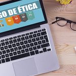 mesa de escritório com notebook com código de ética no monitor