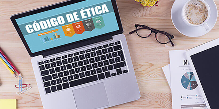 mesa de escritório com notebook com código de ética no monitor